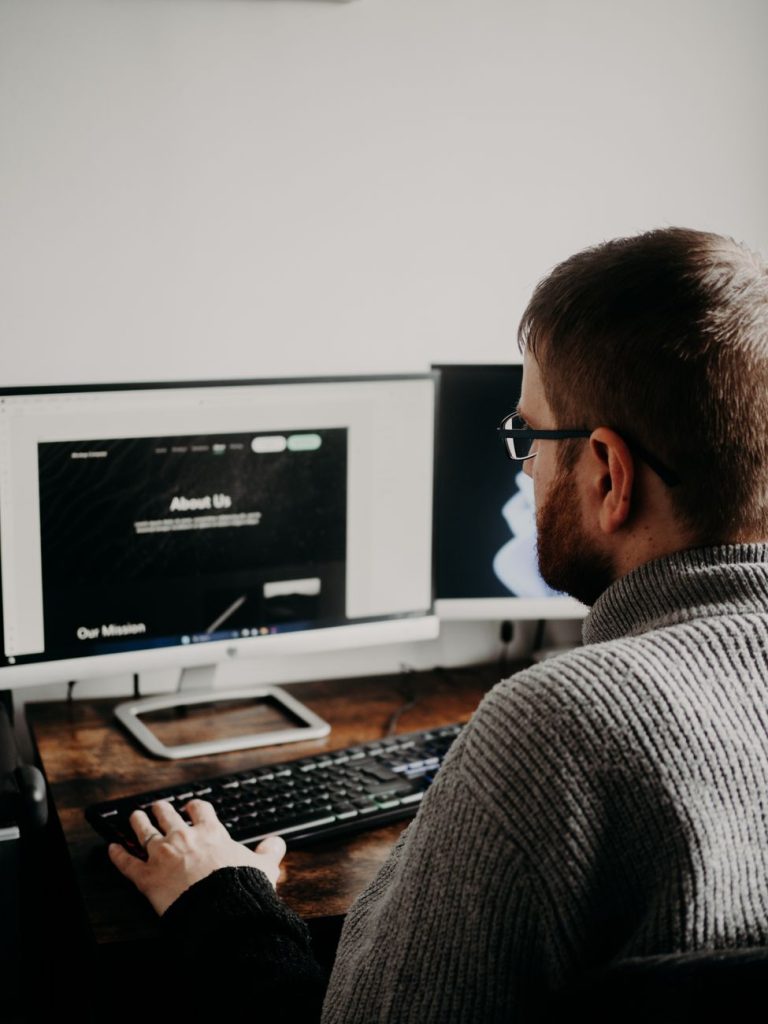 man in glasses working on pc at table