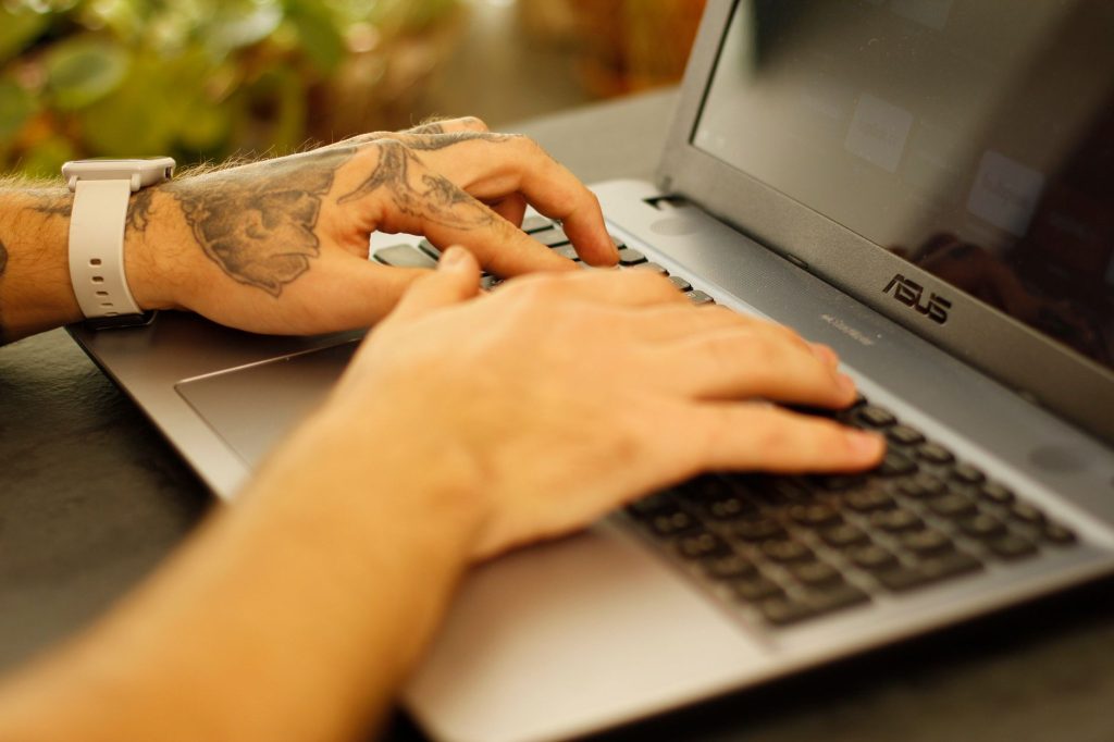 close up shot of a person typing on laptop